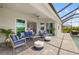 Beautiful screened lanai with a cozy seating area and view of the lush landscaping at 12557 Galapagos Ct, Venice, FL 34293