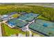 Aerial view of the tennis and pickleball courts available in this beautiful community at 12557 Galapagos Ct, Venice, FL 34293