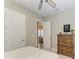 Bright bedroom, with door to dining room, features wooden dresser creating a comfortable and serene space at 14277 Skipping Stone Loop, Parrish, FL 34219