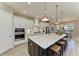 Island kitchen featuring white cabinets, barstool seating, and stainless-steel appliances at 14277 Skipping Stone Loop, Parrish, FL 34219