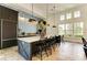 Modern kitchen island featuring a white countertop, stylish pendant lights, and black bar stools at 14277 Skipping Stone Loop, Parrish, FL 34219