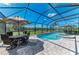 A screened pool features a hot tub with seating under an umbrella at 14277 Skipping Stone Loop, Parrish, FL 34219