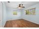 Bedroom with laminated wood floor, ceiling fan, two windows, closet and blue walls at 1665 Harmony Dr, Port Charlotte, FL 33952
