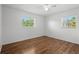 Bedroom with laminated wood floor, a ceiling fan, two windows and white walls at 1665 Harmony Dr, Port Charlotte, FL 33952