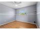Bedroom with laminated wood floor, a ceiling fan, a window and pale blue walls at 1665 Harmony Dr, Port Charlotte, FL 33952