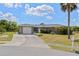 Charming single-story home with a well-maintained lawn, paved driveway, and attached garage, creating curb appeal at 1665 Harmony Dr, Port Charlotte, FL 33952