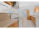 Bright kitchen with wood cabinets, stainless vent hood, tile floor, and appliances ready for your culinary creations at 1665 Harmony Dr, Port Charlotte, FL 33952