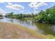 Scenic water view with lush greenery and a bright, partly cloudy sky, creating a tranquil and inviting atmosphere at 1665 Harmony Dr, Port Charlotte, FL 33952
