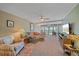 Spacious and inviting living room with neutral décor and large windows and ceiling fan at 1701 Beach Rd # 312, Englewood, FL 34223