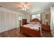 Comfortable bedroom with wood-look floors, ceiling fan, dresser, closet, and natural light at 207 62Nd W St, Bradenton, FL 34209