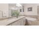 Elegant bathroom featuring double sinks, granite countertops, and a soaking tub at 20892 Cattail Blvd, Venice, FL 34292