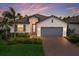 Beautiful home with a two-car garage, a tile roof, nice landscaping, and attractive exterior paint at 20892 Cattail Blvd, Venice, FL 34292