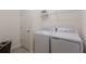 Functional laundry room with white washer and dryer units and ample shelf storage at 20892 Cattail Blvd, Venice, FL 34292