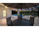 Outdoor dining area with an umbrella and seating overlooks the pool and lush greenery at 20892 Cattail Blvd, Venice, FL 34292