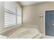 Bathroom showing a large jacuzzi tub, neutral tile, and plantation shutters on the window at 22235 Panther Loop, Bradenton, FL 34202