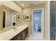 A well-lit bathroom offers a tiled floor, white sink, and a vanity with dark wood cabinets at 22235 Panther Loop, Bradenton, FL 34202