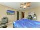 A cozy bedroom is equipped with a ceiling fan, TV, and furniture at 22235 Panther Loop, Bradenton, FL 34202