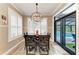 Dining room with views to the pool, a modern chandelier, and wood-look tile floors at 22235 Panther Loop, Bradenton, FL 34202