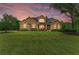 Beautiful stone home featuring a manicured lawn and colorful landscaping at 22235 Panther Loop, Bradenton, FL 34202