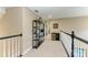 Upstairs hallway with carpet flooring, decorative shelving, and a railing overlooking the floor below at 22235 Panther Loop, Bradenton, FL 34202