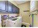 A laundry room features plenty of cabinet space, washer and dryer, and natural light from the window at 22235 Panther Loop, Bradenton, FL 34202