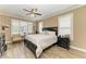 Main bedroom with multiple windows, ceiling fan, and wood-look tile floors at 22235 Panther Loop, Bradenton, FL 34202
