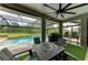 Enjoy outdoor dining and relaxation on this covered patio, complete with a grill and view of the pool at 22235 Panther Loop, Bradenton, FL 34202