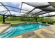 Lovely screened pool has a spa, waterfall feature, and stone surroundings, with outdoor seating at 22235 Panther Loop, Bradenton, FL 34202