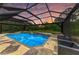 Beautiful screened pool has a spa, waterfall feature, and stone surroundings at 22235 Panther Loop, Bradenton, FL 34202