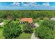 Expansive aerial view of home featuring a terracotta roof, mature trees, and lush green lawn at 22333 Panther Loop, Bradenton, FL 34202