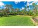 Large backyard with lawn, mature trees, and outdoor seating around a firepit at 22333 Panther Loop, Bradenton, FL 34202