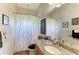 Bathroom featuring granite countertop, decorative mirror, and a shower with a patterned curtain at 22333 Panther Loop, Bradenton, FL 34202