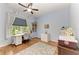 Bright bedroom featuring hardwood floors, sewing station, natural light, and neutral blue painted walls at 22333 Panther Loop, Bradenton, FL 34202