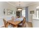Traditional dining room with a wood table, chandelier, and blue curtains with an adjacent view into the living room at 22333 Panther Loop, Bradenton, FL 34202