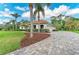 Beautiful exterior featuring a circular driveway, lush landscaping, and palm trees at 22333 Panther Loop, Bradenton, FL 34202