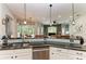 Bright eat-in kitchen with white cabinetry and stainless steel appliances offering views of the living area at 22333 Panther Loop, Bradenton, FL 34202