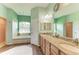 En suite bathroom with dual sinks, tub, walk-in shower and wood flooring at 22333 Panther Loop, Bradenton, FL 34202