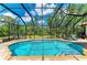 Sparkling screened-in pool with brick pavers and lush views of the surrounding greenery and blue skies at 22333 Panther Loop, Bradenton, FL 34202
