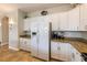 Bright kitchen featuring white cabinets, stainless appliances, and granite countertops at 2309 Avenue C # 100, Bradenton Beach, FL 34217