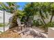 Cozy brick patio featuring two Adirondack chairs, landscaping, and privacy fencing for a relaxing outdoor retreat at 2309 Avenue C # 100, Bradenton Beach, FL 34217