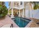 Luxury home featuring a private pool with lounging chairs and lush landscaping, creating an outdoor oasis at 2309 Avenue C # 100, Bradenton Beach, FL 34217