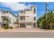 Three-story home featuring a two-car garage, balconies, a stucco exterior, and a brick-paved driveway at 2309 Avenue C # 200, Bradenton Beach, FL 34217