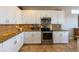 Elegant kitchen with white cabinets, granite countertops, tile backsplash, and stainless steel appliances at 2309 Avenue C # 200, Bradenton Beach, FL 34217