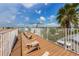 A relaxing rooftop deck is surrounded by a white privacy fence, and is lined with Adirondack chairs to enjoy the weather at 2309 Avenue C # 200, Bradenton Beach, FL 34217