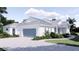 Attractive single story home with a two car garage, light gray metal roof, and beautifully landscaped front yard at 2508 Belvoir Blvd, Sarasota, FL 34237