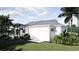 Beautiful white home featuring a screened in lanai and pool nestled among lush green landscaping at 2508 Belvoir Blvd, Sarasota, FL 34237