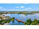 Scenic aerial view of a waterfront community with a wooden pier, lush green landscaping, and beautiful blue water at 2894 Butterfly Jasmine Trl, Sarasota, FL 34240