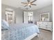 Inviting bedroom featuring a comfortable bed, ceiling fan, and large dresser for ample storage, creating a cozy retreat at 2894 Butterfly Jasmine Trl, Sarasota, FL 34240