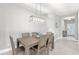 A dining room featuring a wooden table with seating for six under a modern light fixture, creating a cozy atmosphere at 2894 Butterfly Jasmine Trl, Sarasota, FL 34240