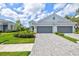 Charming single-Gathering home featuring a paver driveway, manicured lawn, and two-car garage at 2894 Butterfly Jasmine Trl, Sarasota, FL 34240